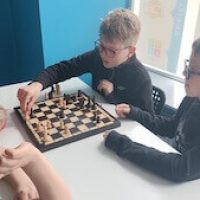 Dzieci podczas gier w szachy na półkoloniach zimowych w Łodzi organizowanych przez Baby English Center